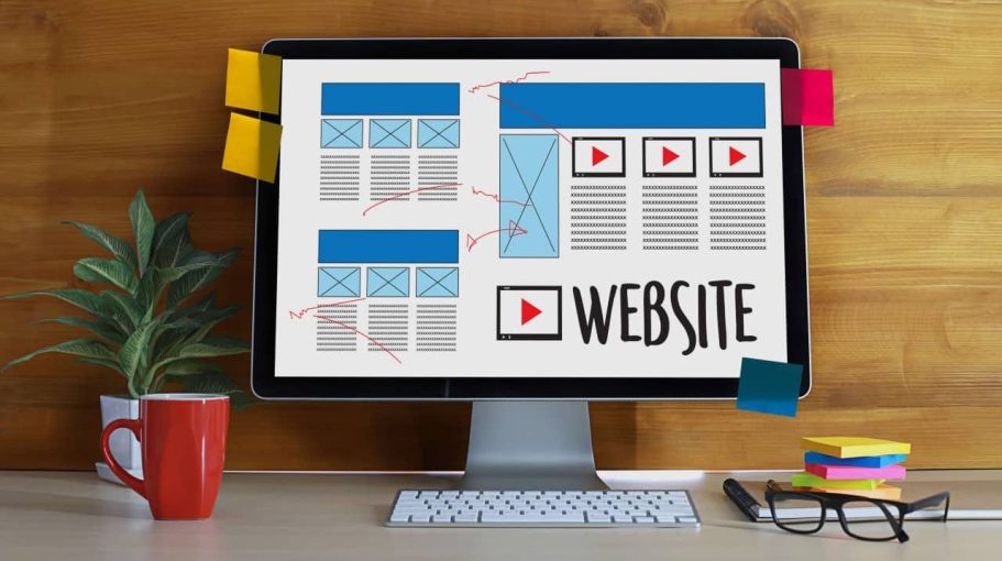 Écran d'ordinateur affichant un design de site web avec des croquis et des notes.