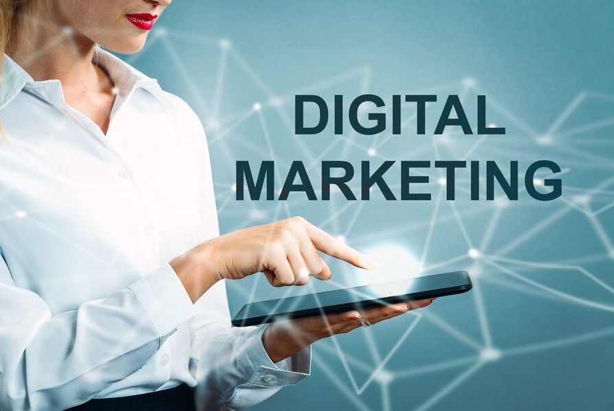 Femme en chemise pointant vers un écran, avec "DIGITAL MARKETING" en arrière-plan.